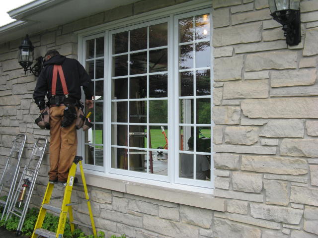A service technician repairing a window